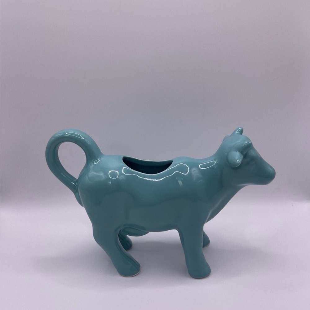 This is a Food Network ceramic cow creamer in a teal or turquoise blue color